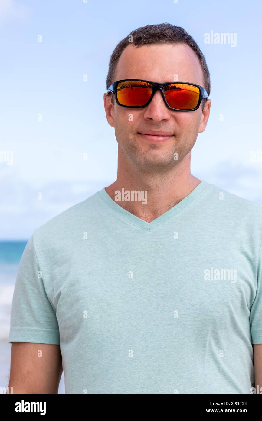 Close up portrait of young adult Caucasian man in shiny red sunglasses Stock Photo