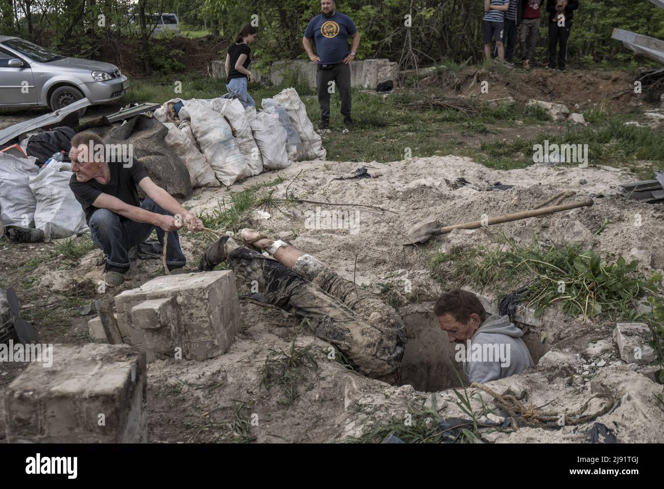 Malaya Rohan, Ukraine. 19th May, 2022. Men pull the bodies of two dead Russian soldiers out from where he was buried in a persons front yard in Mala Rohan, Ukraine, Thursday, May 19, 2022. Mala Rohan is a small village retaken by the Ukrainian forces, after Russia's attack on Ukraine. EDITORS NOTE CONTENT. Photo by Ken Cedeno/UPI Credit: UPI/Alamy Live News Stock Photo