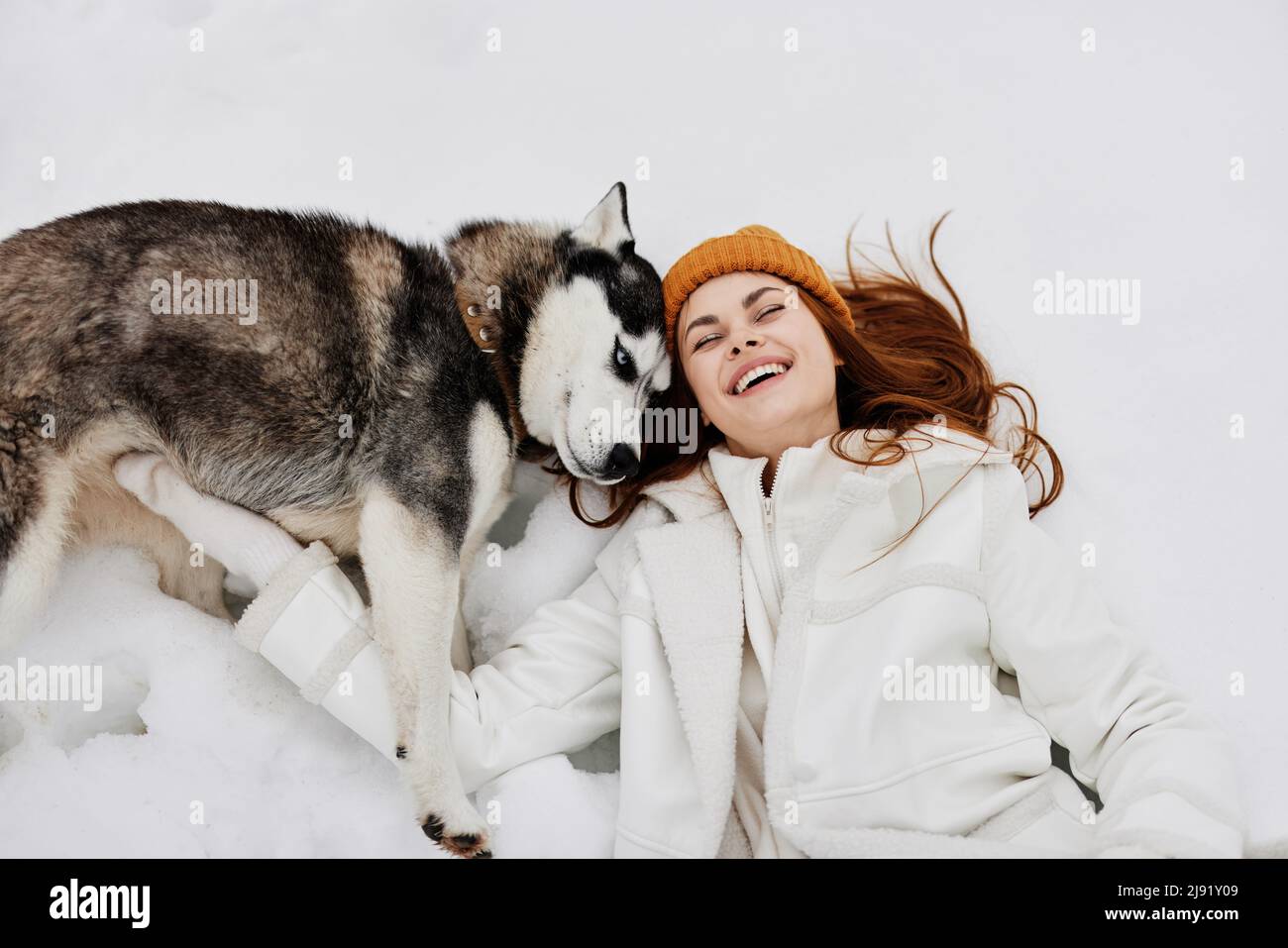 young woman winter clothes walking the dog in the snow fresh air Stock