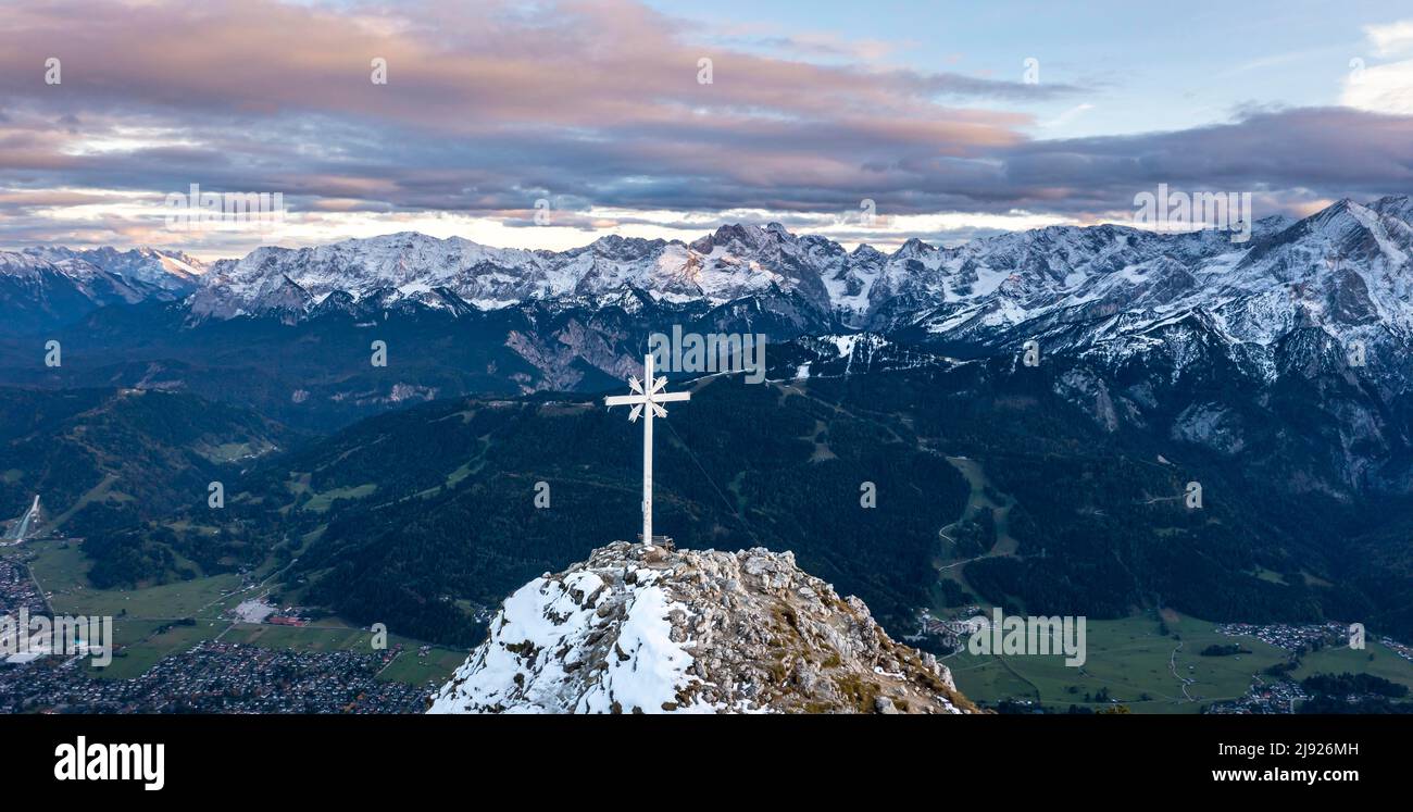 Alpine panorama with Zugspitze and summit cross of the Kramer, aerial view, mountains with snow in the evening, summit of the Kramer, Garmisch Stock Photo