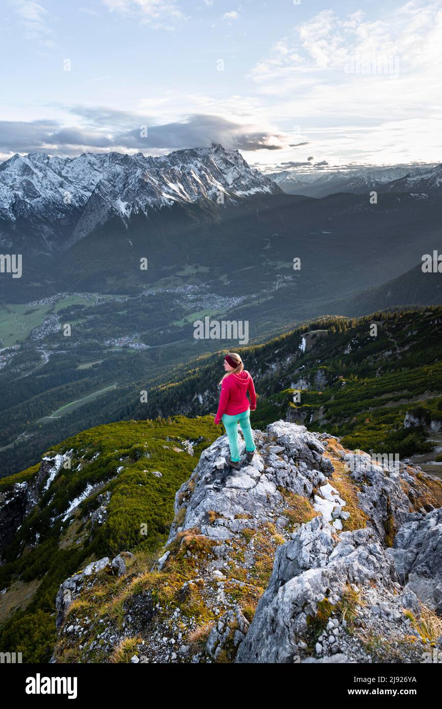 Young hiker at the Kramerspitz, Wetterstein Mountains and Zugspitze in the background, Bavaria, Germany Stock Photo