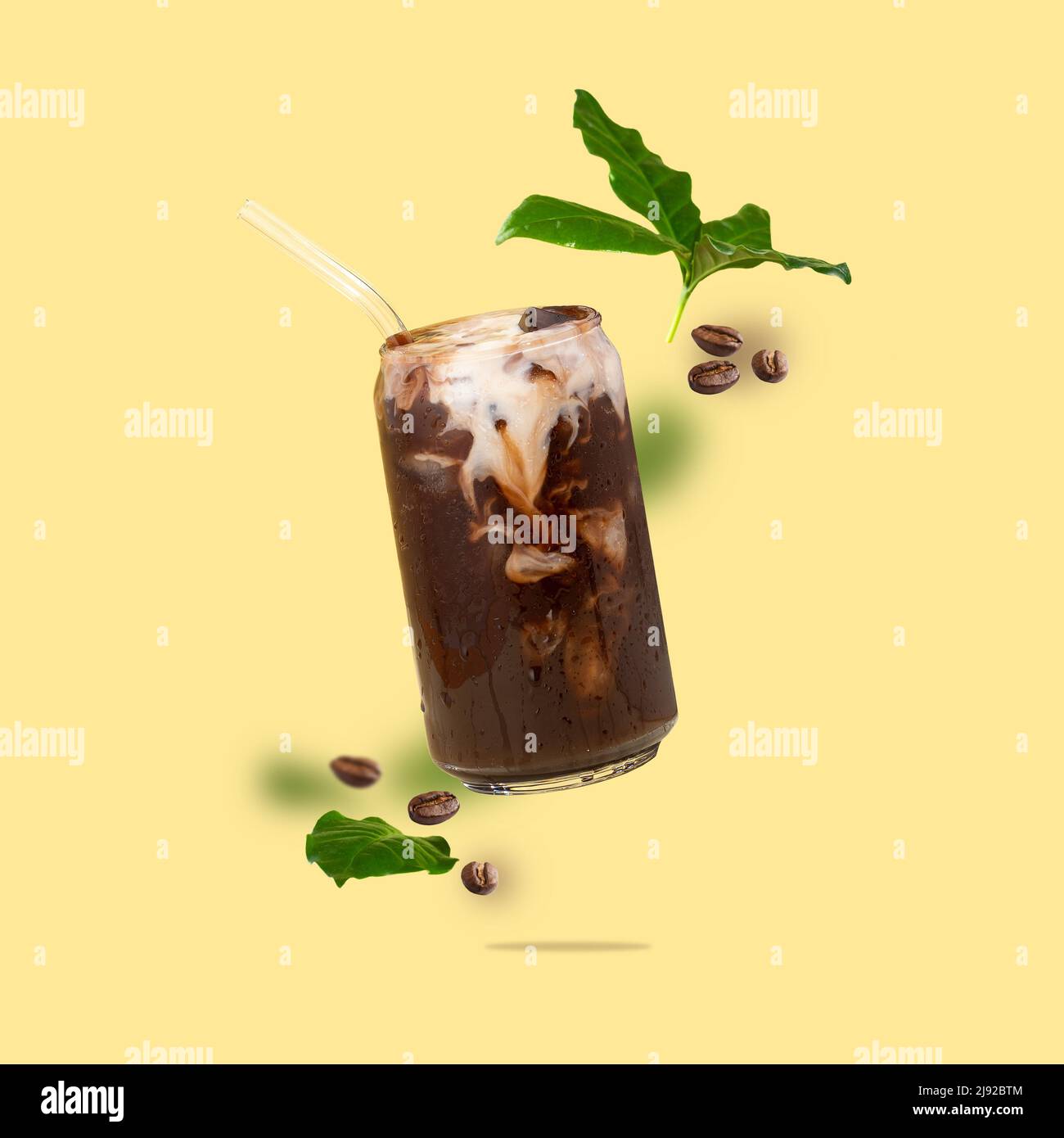 Floating canshaped glass cup with coffee, coffee beans, coffee leaves flying on a yellow