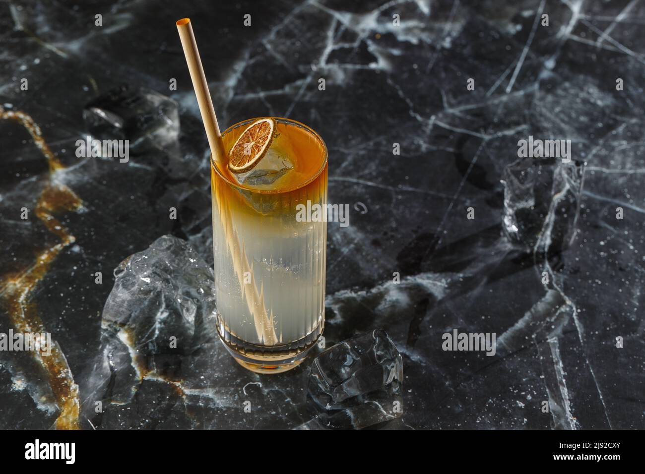 Dark n Stormy cocktail standing on the black marble background. Refreshing Boozy Rum Dark and Stormy Cocktail with Ginger Beer Stock Photo