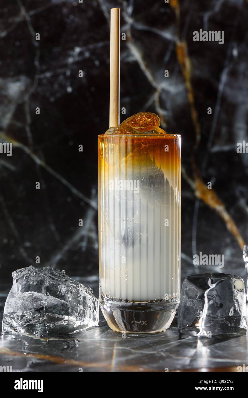 Dark n Stormy cocktail standing on the black marble background. Refreshing Boozy Rum Dark and Stormy Cocktail with Ginger Beer Stock Photo