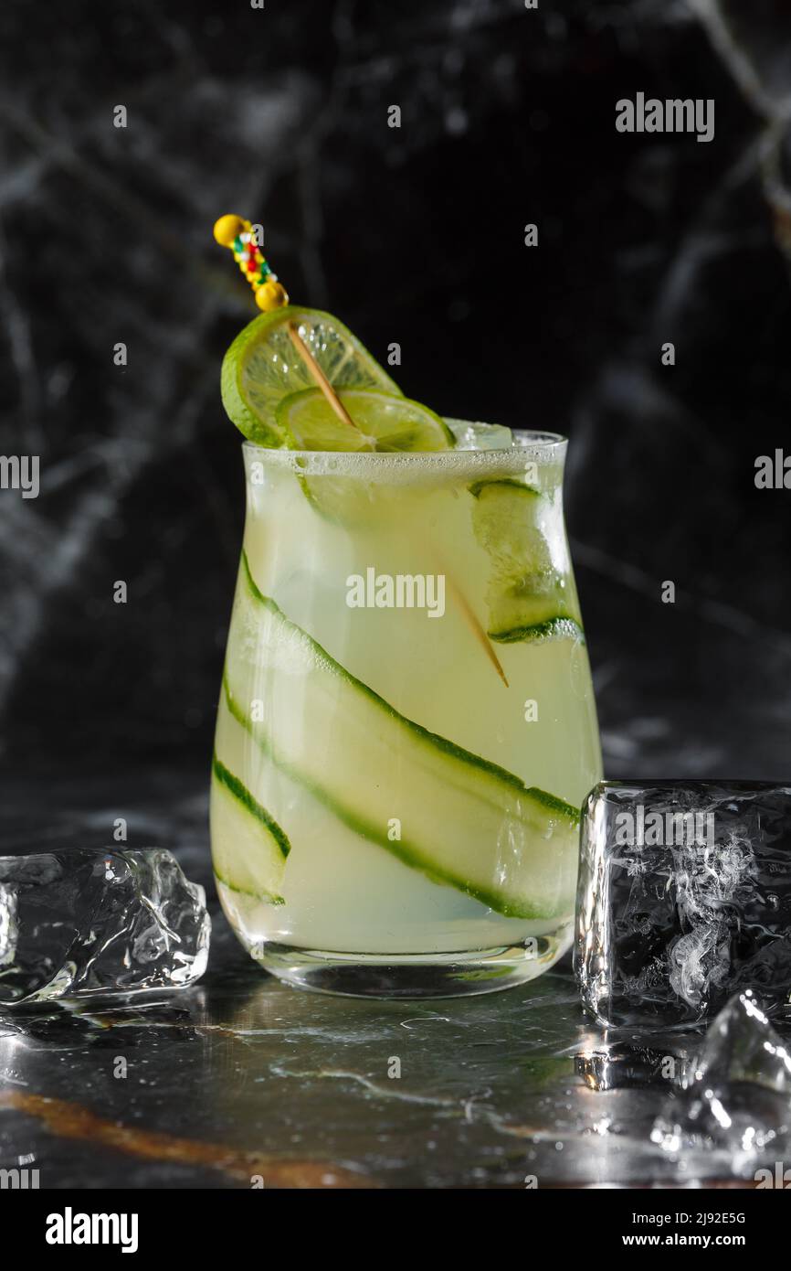 Gin gimlet cocktail garnished with cucumber. Green alcohol cocktail