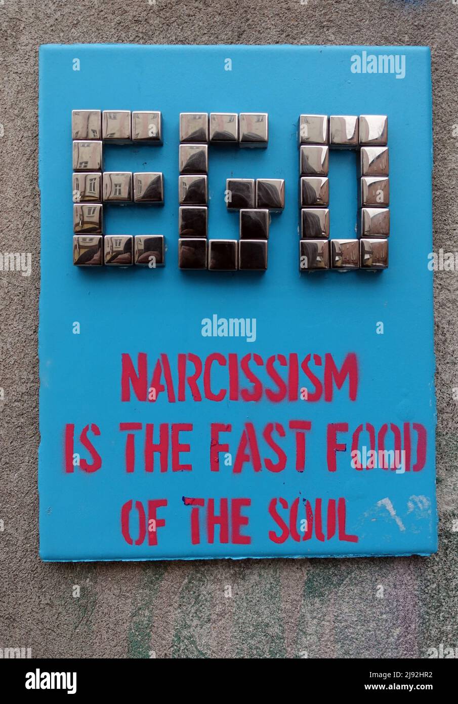 26.01.2019, Krakau, Lesser Poland, Poland - Street art: stone slab with the inscription EGO Narcissism is the Fast Food of the Soul hangs on a house w Stock Photo
