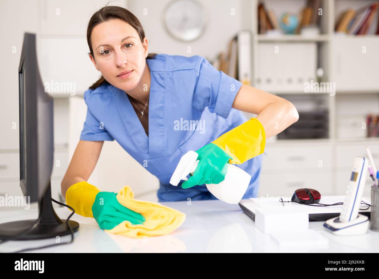 Portrait of a young woman cleaning an office desk Stock Photo - Alamy