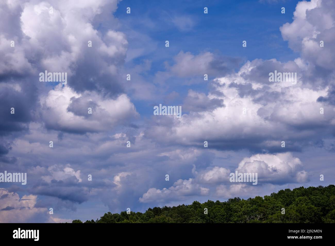 Dramatic fluffy cloudscape and deep blue sky Stock Photo