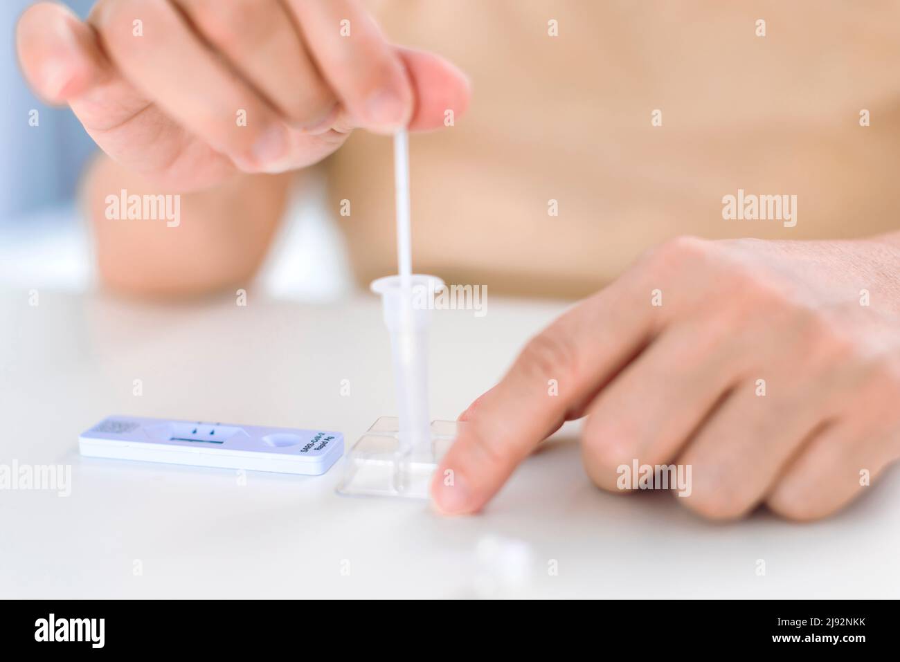 Closeup Woman using coronavirus covid-19 rapid antigen home testing kit Stock Photo