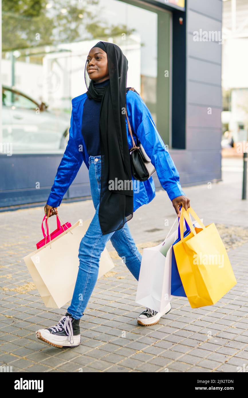 Muslim shopaholic strolling on street Stock Photo