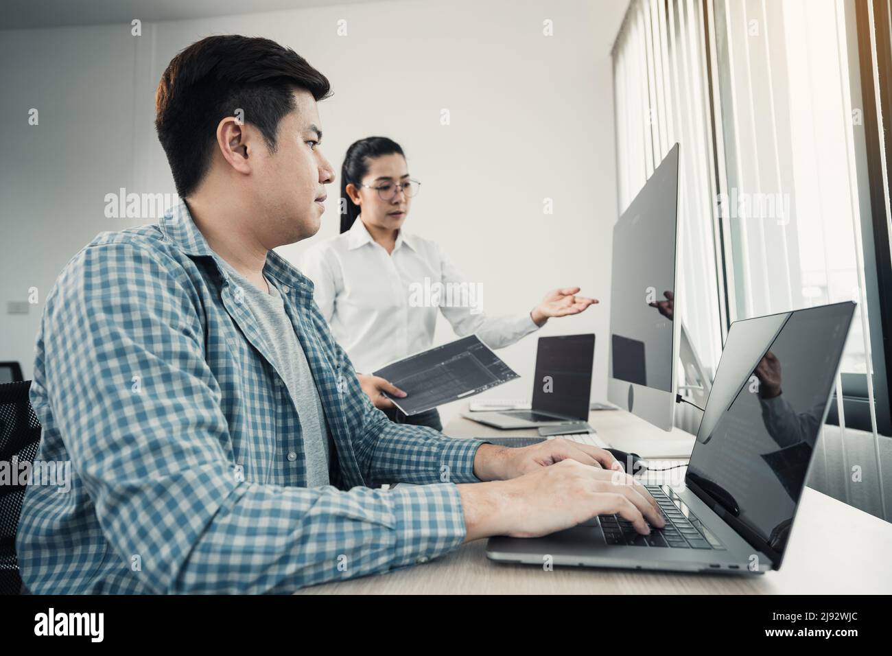 Two asian team working development of programming and encryption technology website design programmers on desk in office. Stock Photo