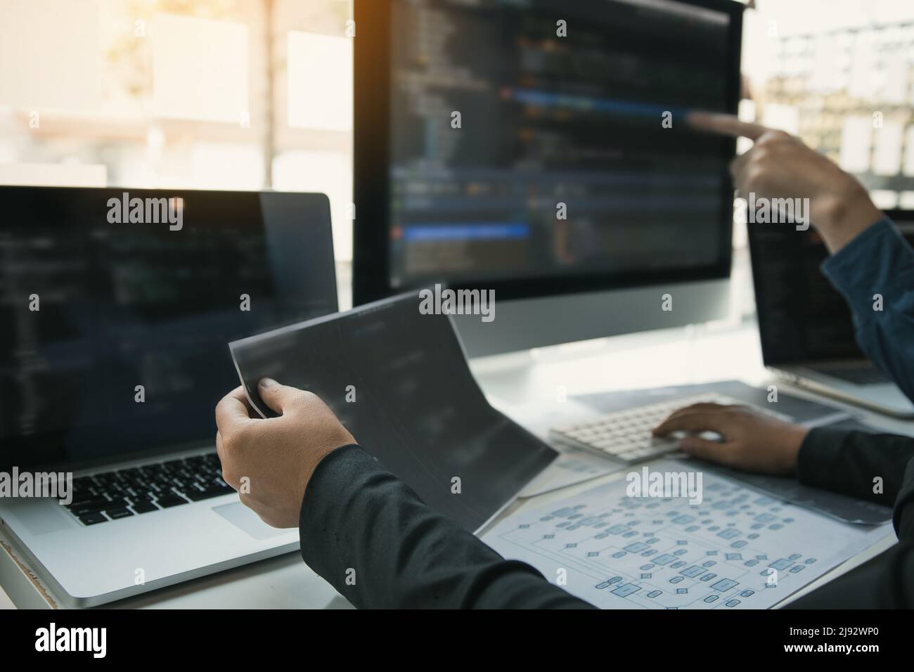 Two software developers are analyzing together about the code written into the program on the computer. Stock Photo