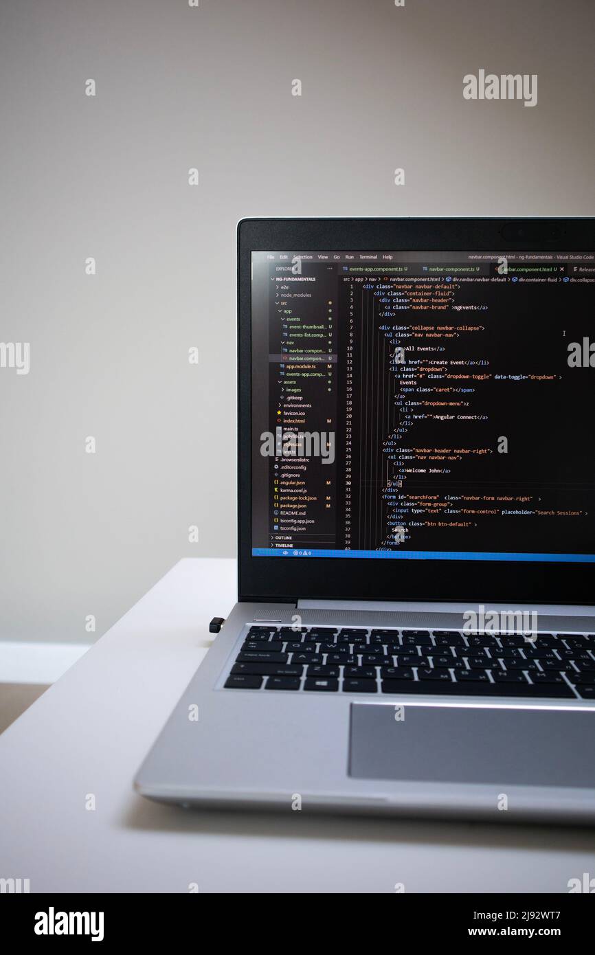 Opened laptop with code on the screen on the table Stock Photo