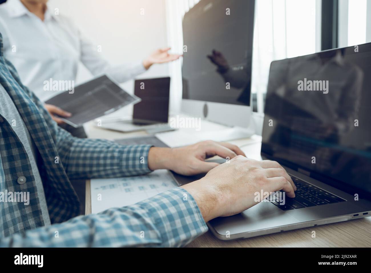 Two partnerships developing programming and coding technologies working on laptop and analyzing together. Stock Photo