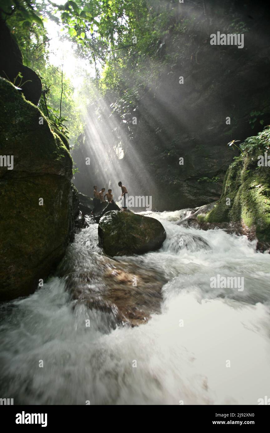 Bathing With Rocks Children having recreational time by bathing and standing on rocks on a ...