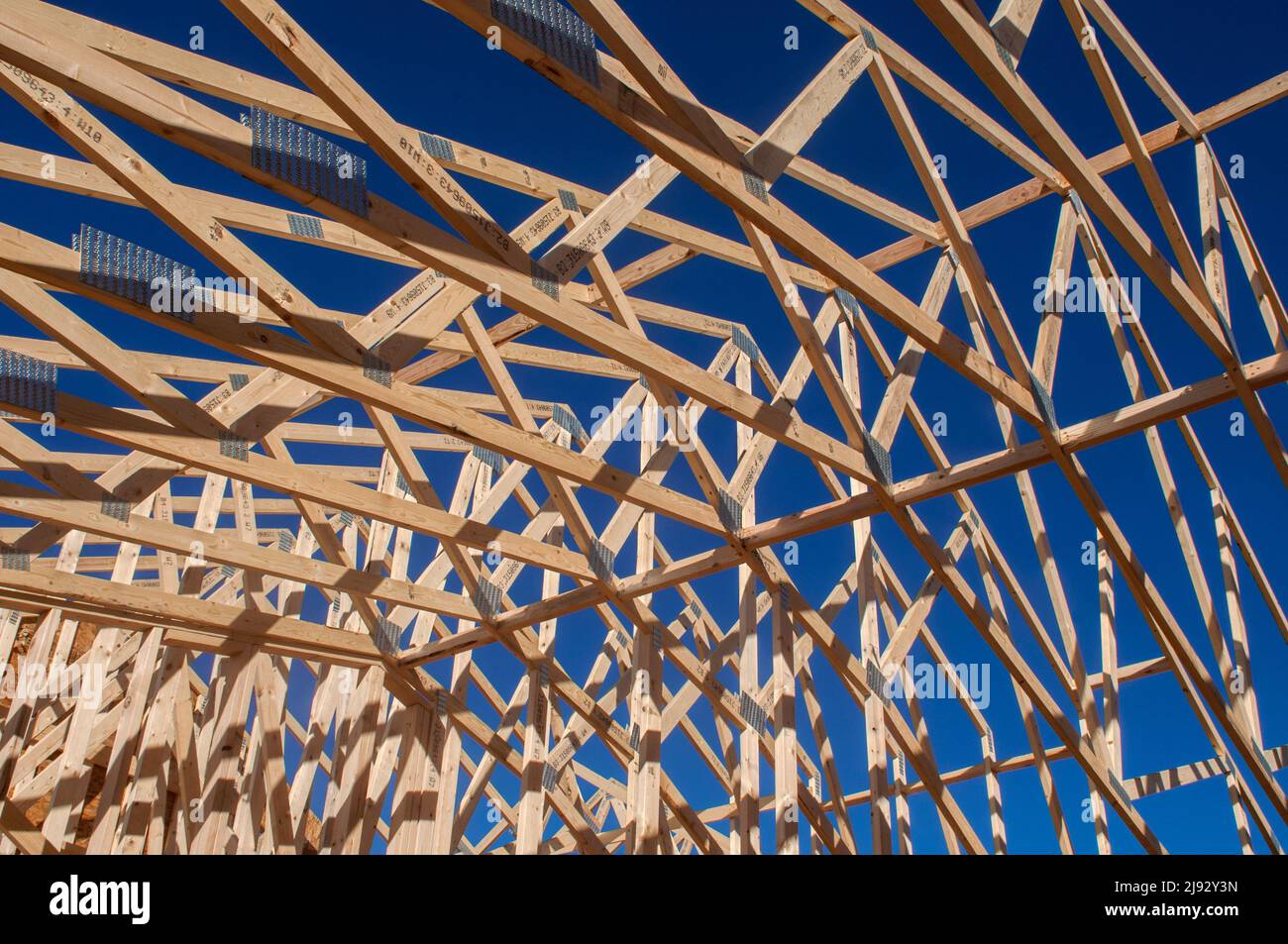 Structural supports and roof trusses of a house under construction. Stock Photo