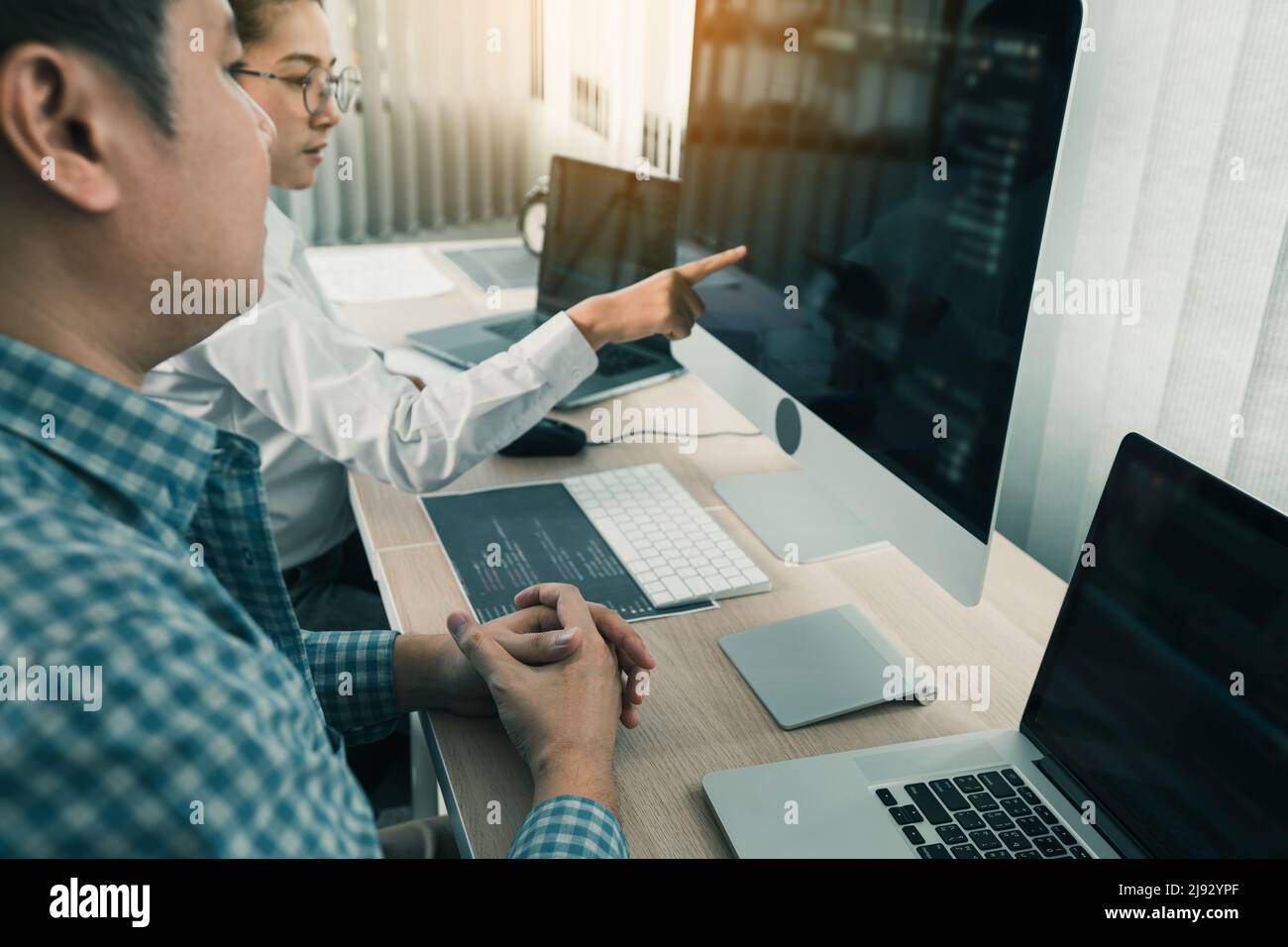 Two asian team working development of programming and encryption technology website design programmers on desk in office. Stock Photo