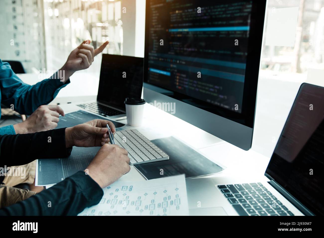 Two partnerships developing programming and coding technologies working on laptop and analyzing together. Stock Photo