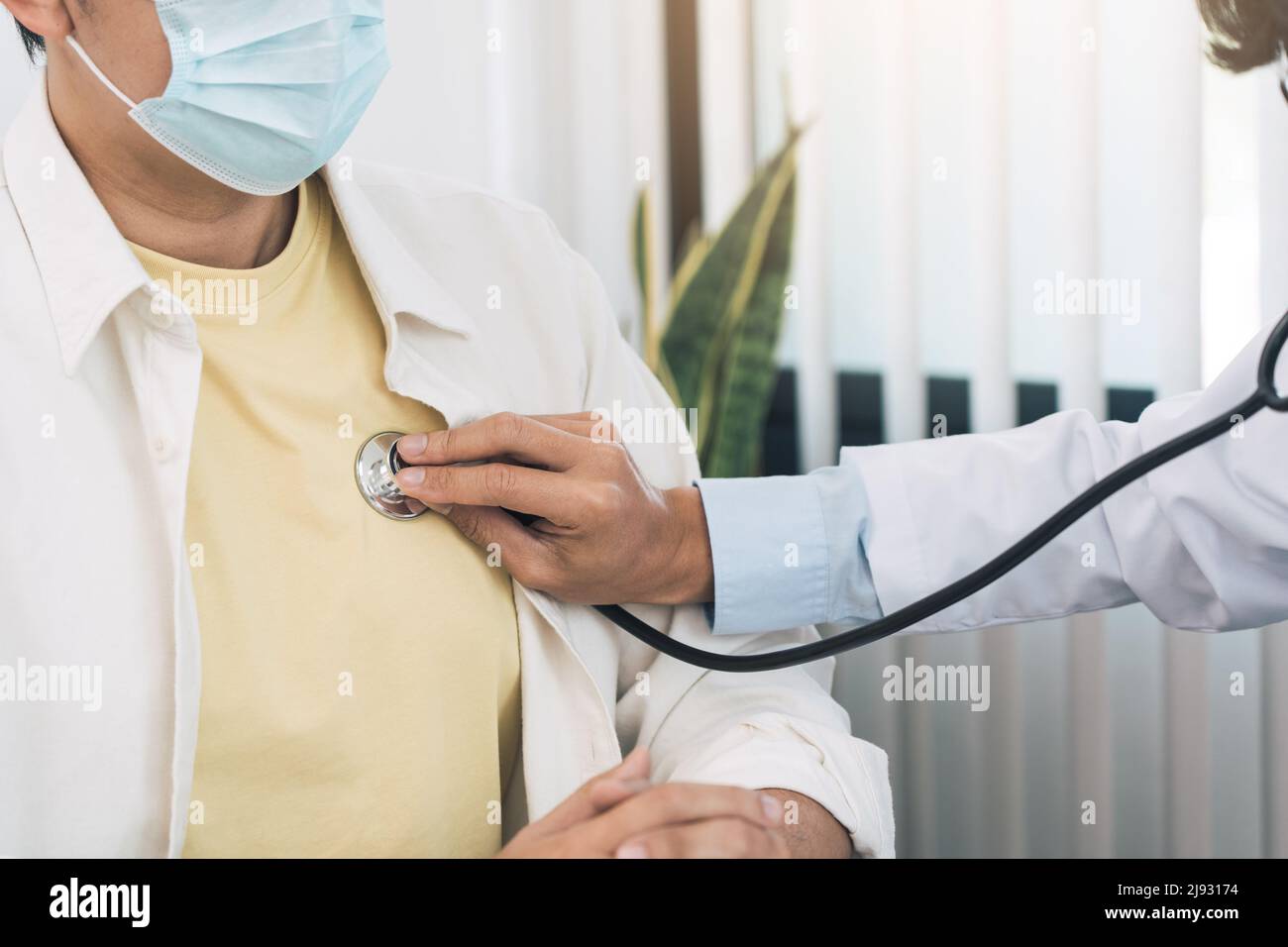Asian doctor is using a stethoscope listen to the heartbeat of the ...