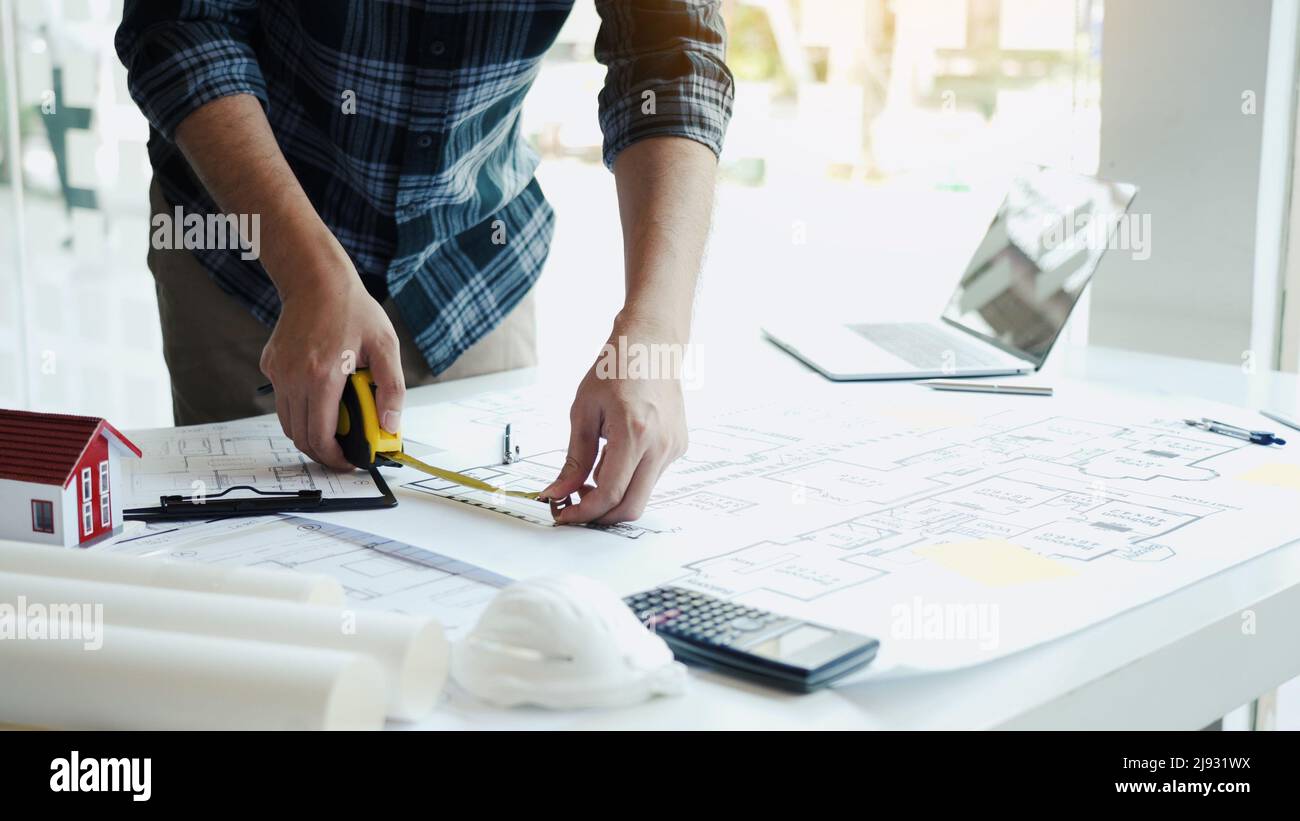 Architects are working on a new project while using a tape measure. Stock Photo
