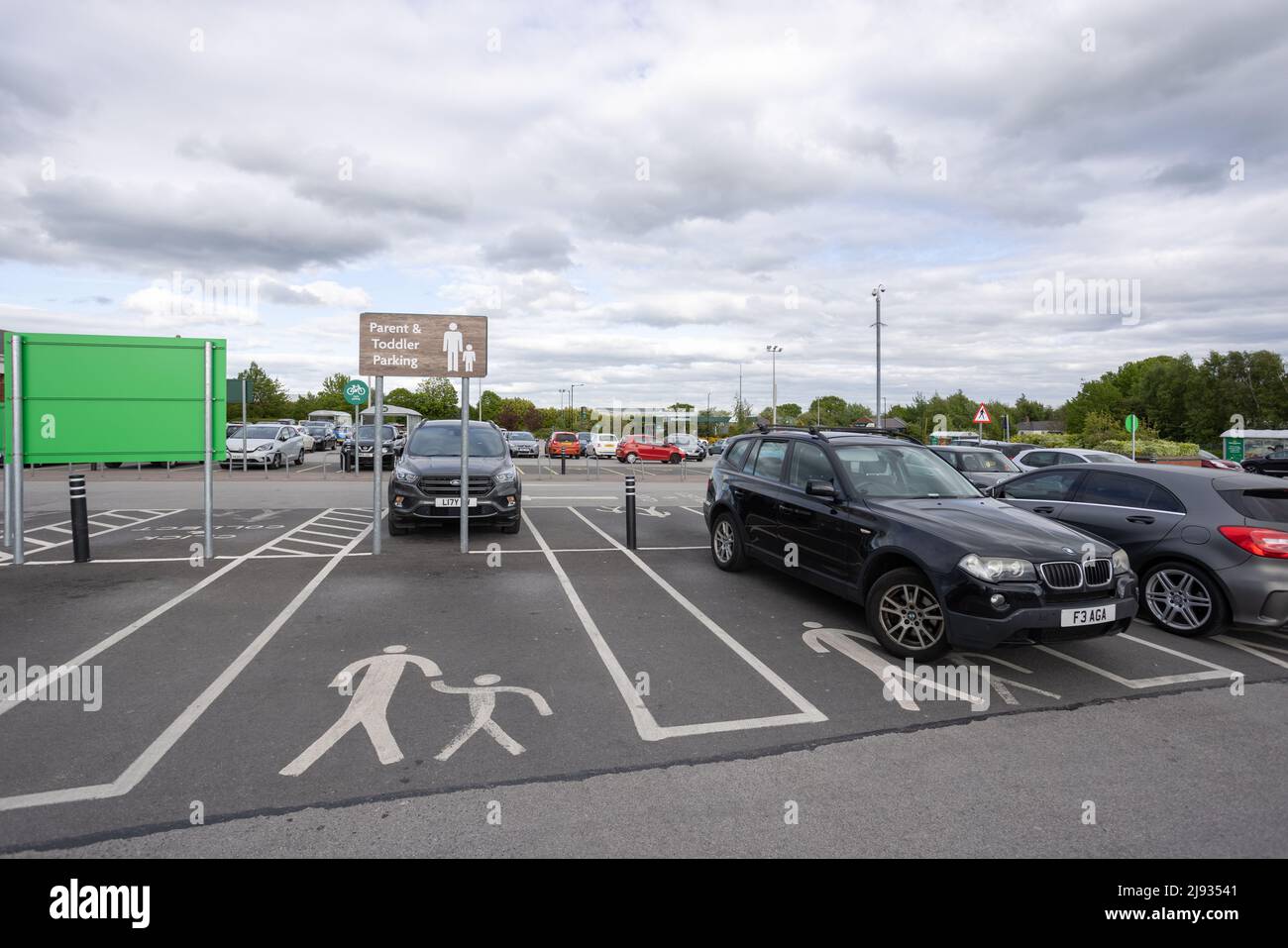 Parent and toddler parking sign at Morrisons supermarket car park and icon painted on ground in parking space Stock Photo