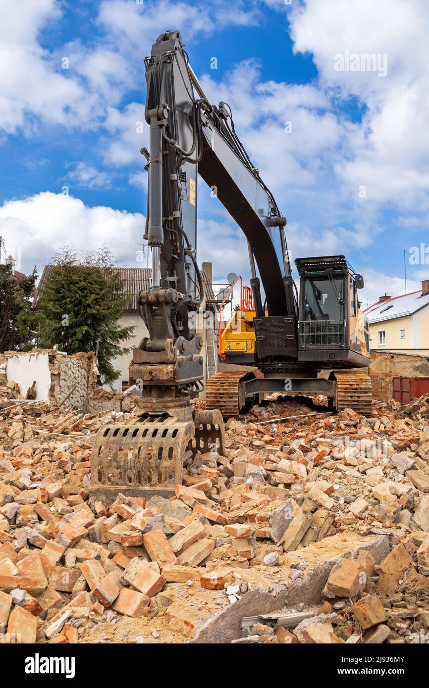Excavator on debris of a demolished building in Germany Stock Photo