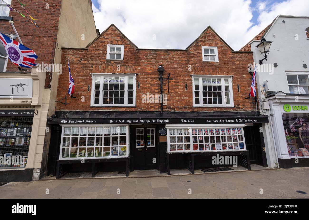 Oldest Chemist Shop in England, Knaresborough with English flag waving for queen Jubilee 2022 in Knaresborough North Yorkshire Stock Photo