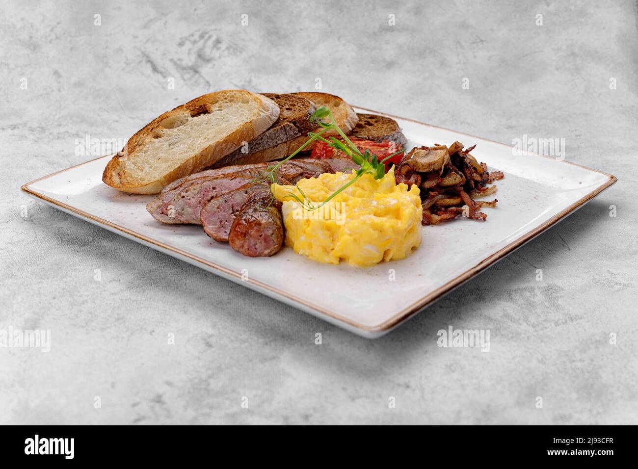 Irish breakfast on a plate. Sausage, scrambled eggs, mushrooms, bacon