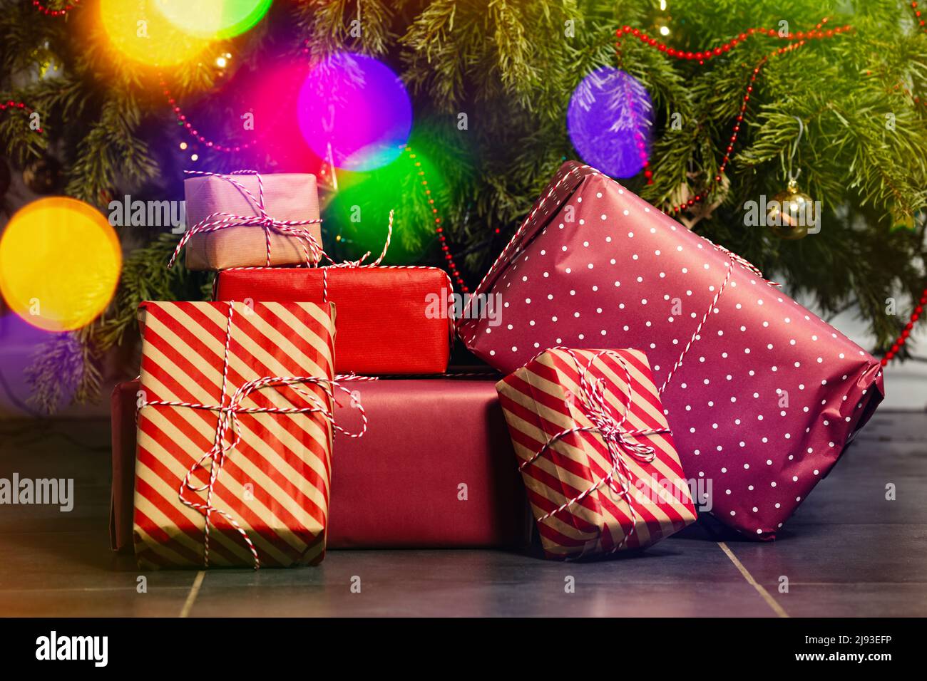 Many different present boxes stacked lay under Christmas tree Stock Photo