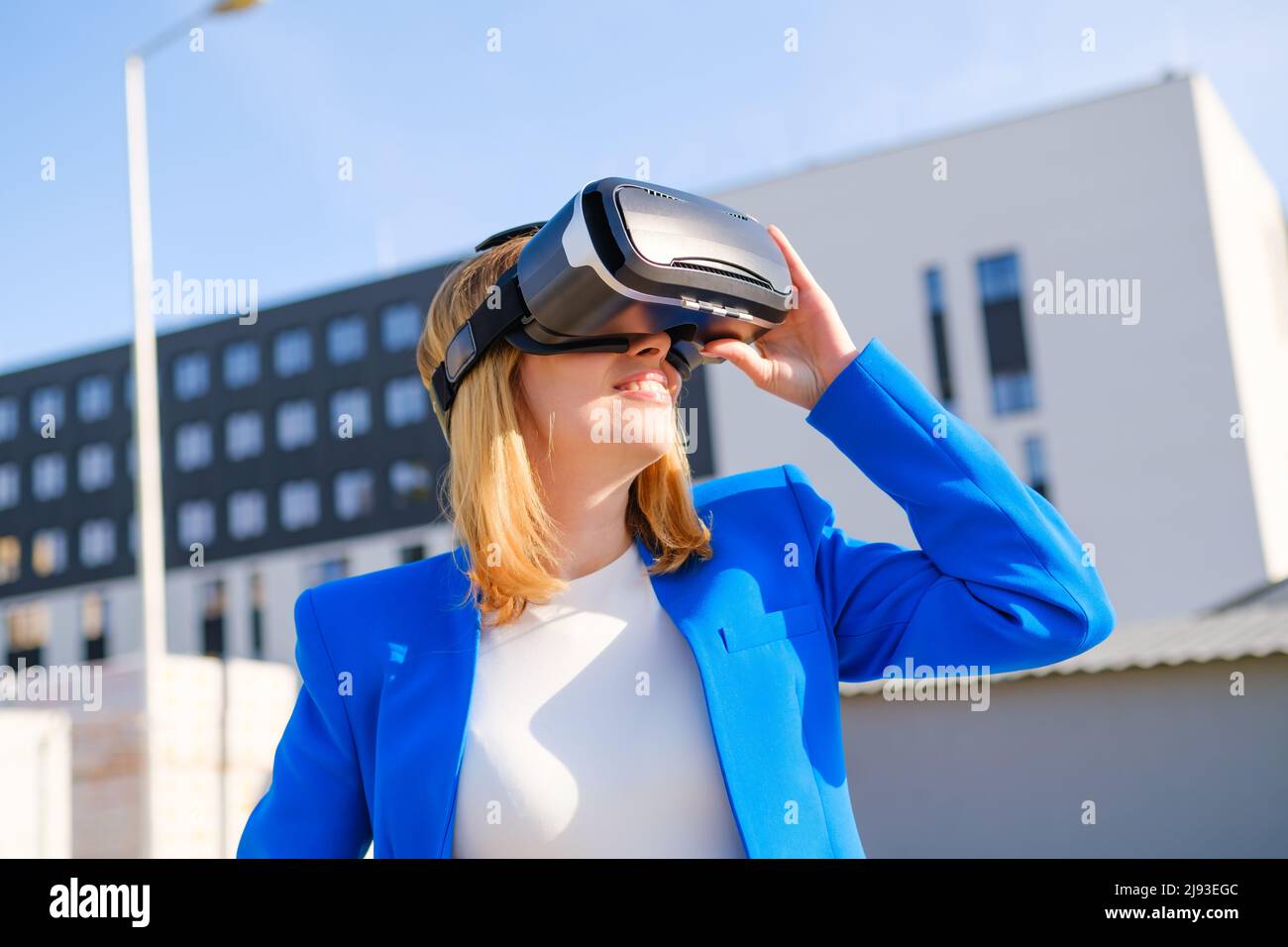 Smiling woman in vr glasses experiencing augmented reality in front of ...