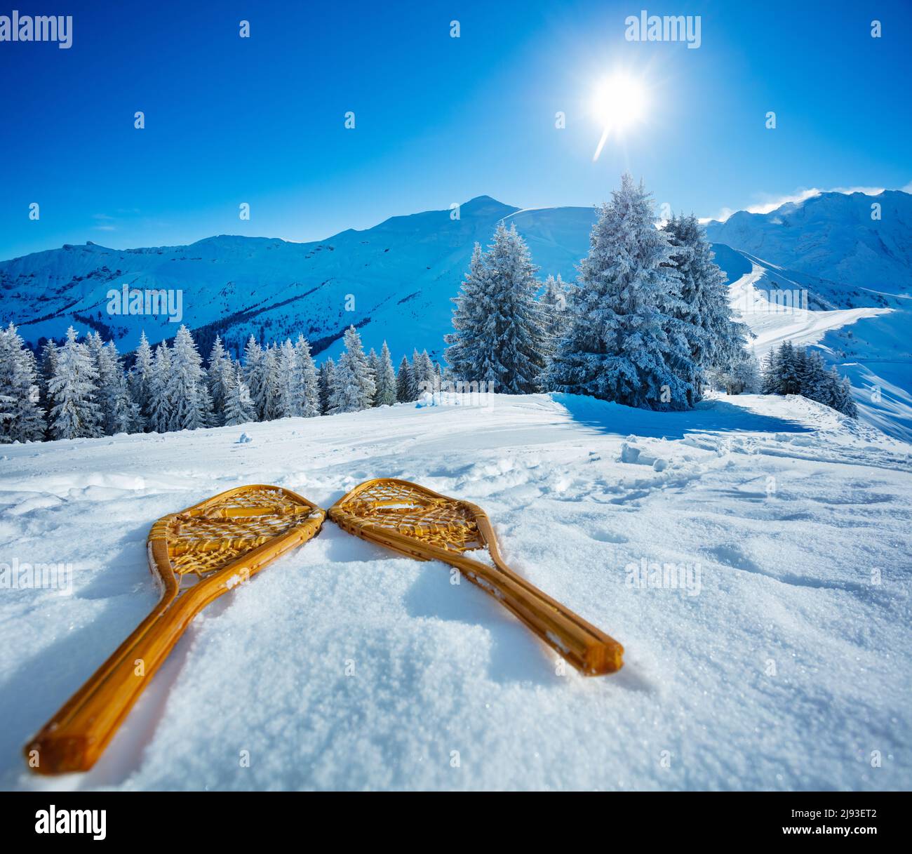 Wooden snowshoes in the snow over mountains and snowy forest Stock Photo