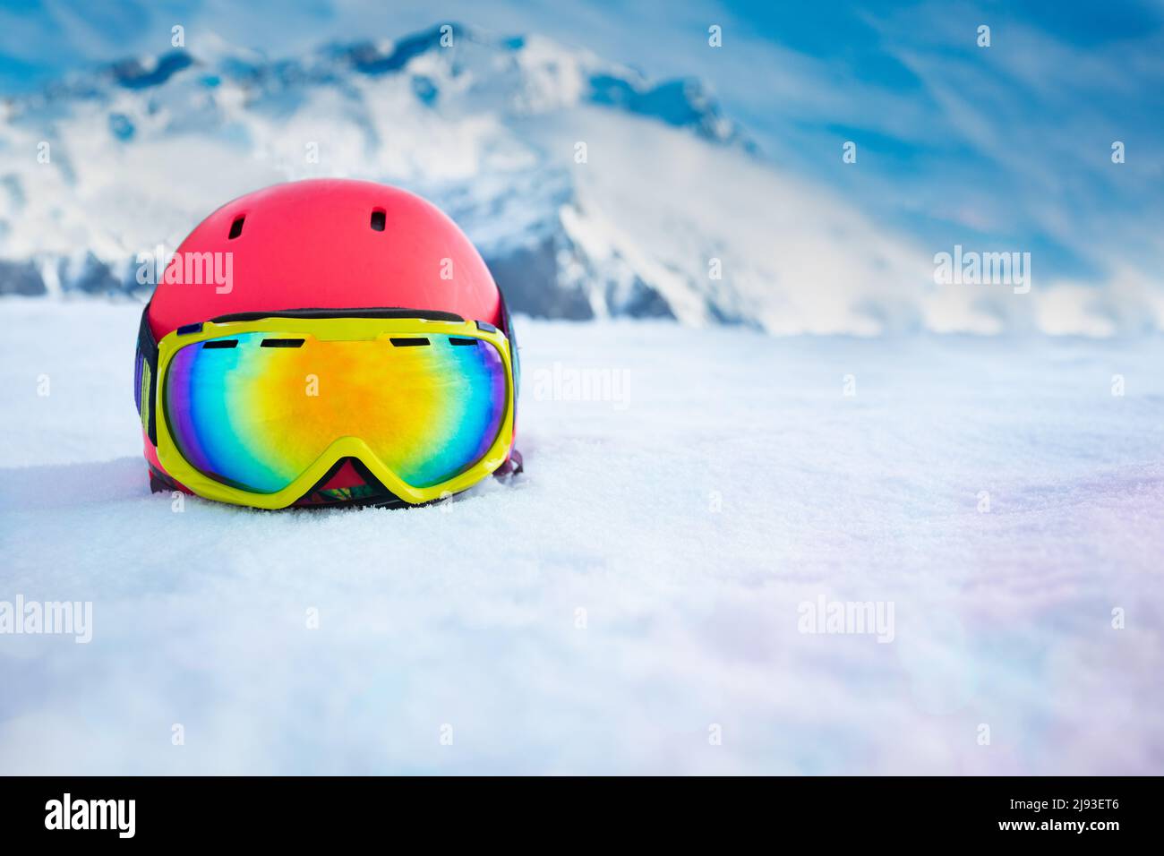 Pink helmet with ski mask in snow over mountain range Stock Photo