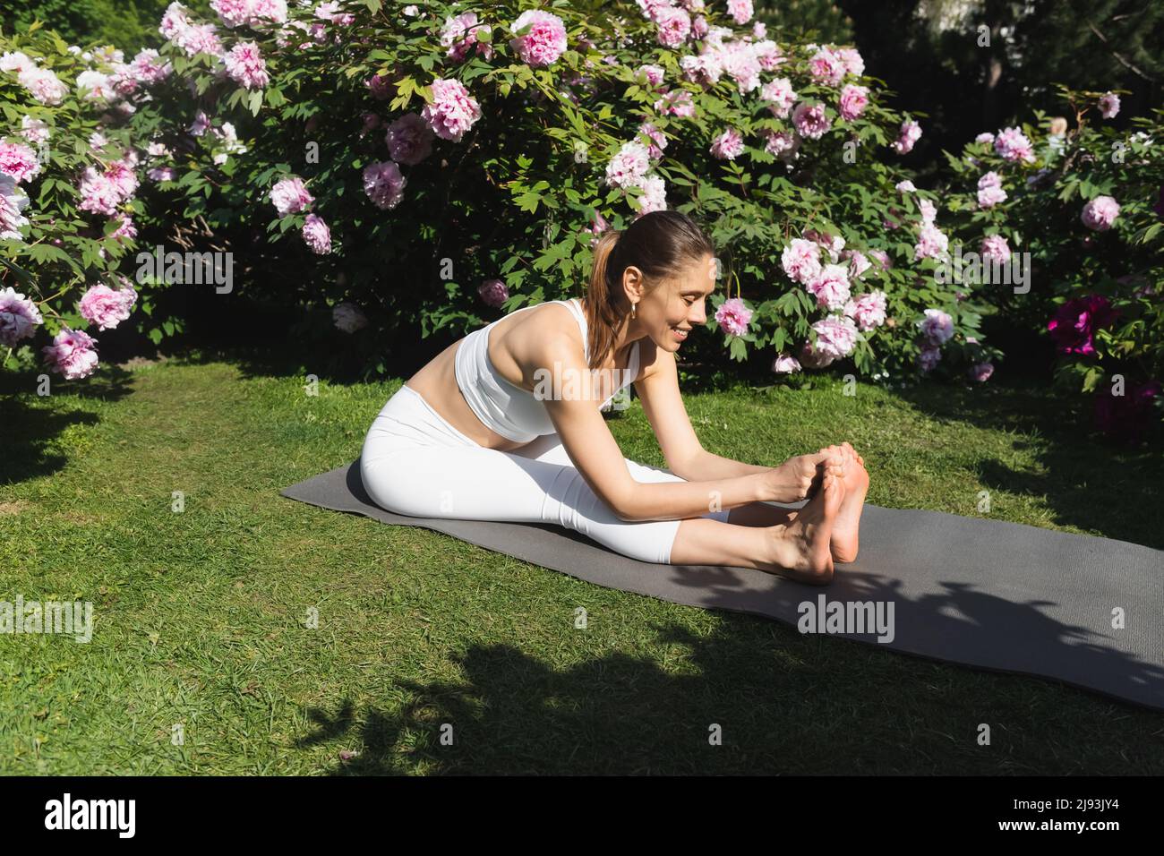 Smiling Girl Exercising Yoga - Seated Forward Fold Stock Photo - Image of  grey, dress: 168157300