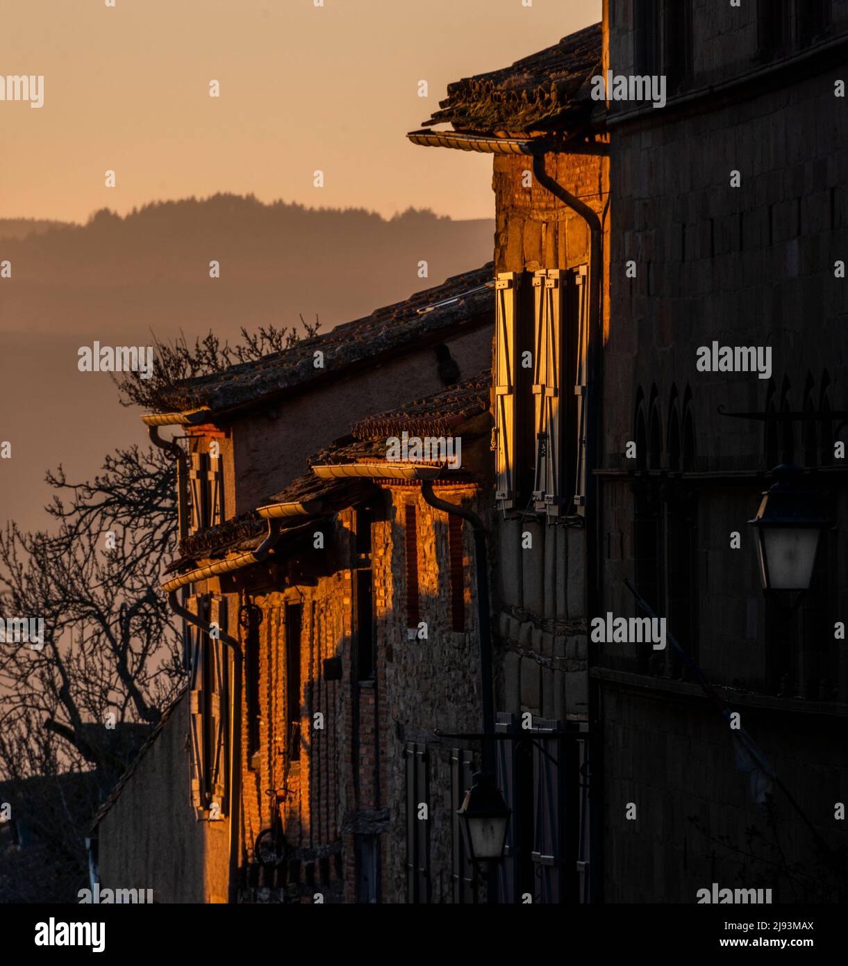 Sunset illuminating the facades of houses in the medieval hilltop village of Cordes-sur-Ciel in the Tarn department of Occitanie, France. Stock Photo
