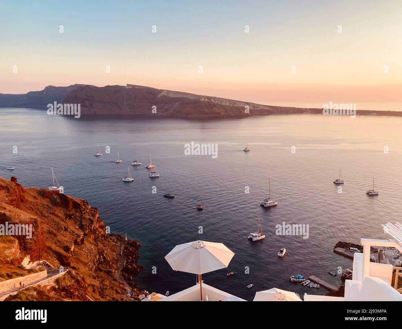 Boats arriving to view the sunset over the greek island of Santorini Stock Photo