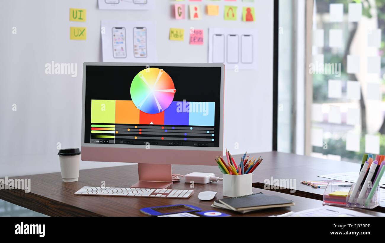 Design studio with computer, color swatches and wireframe sketches for