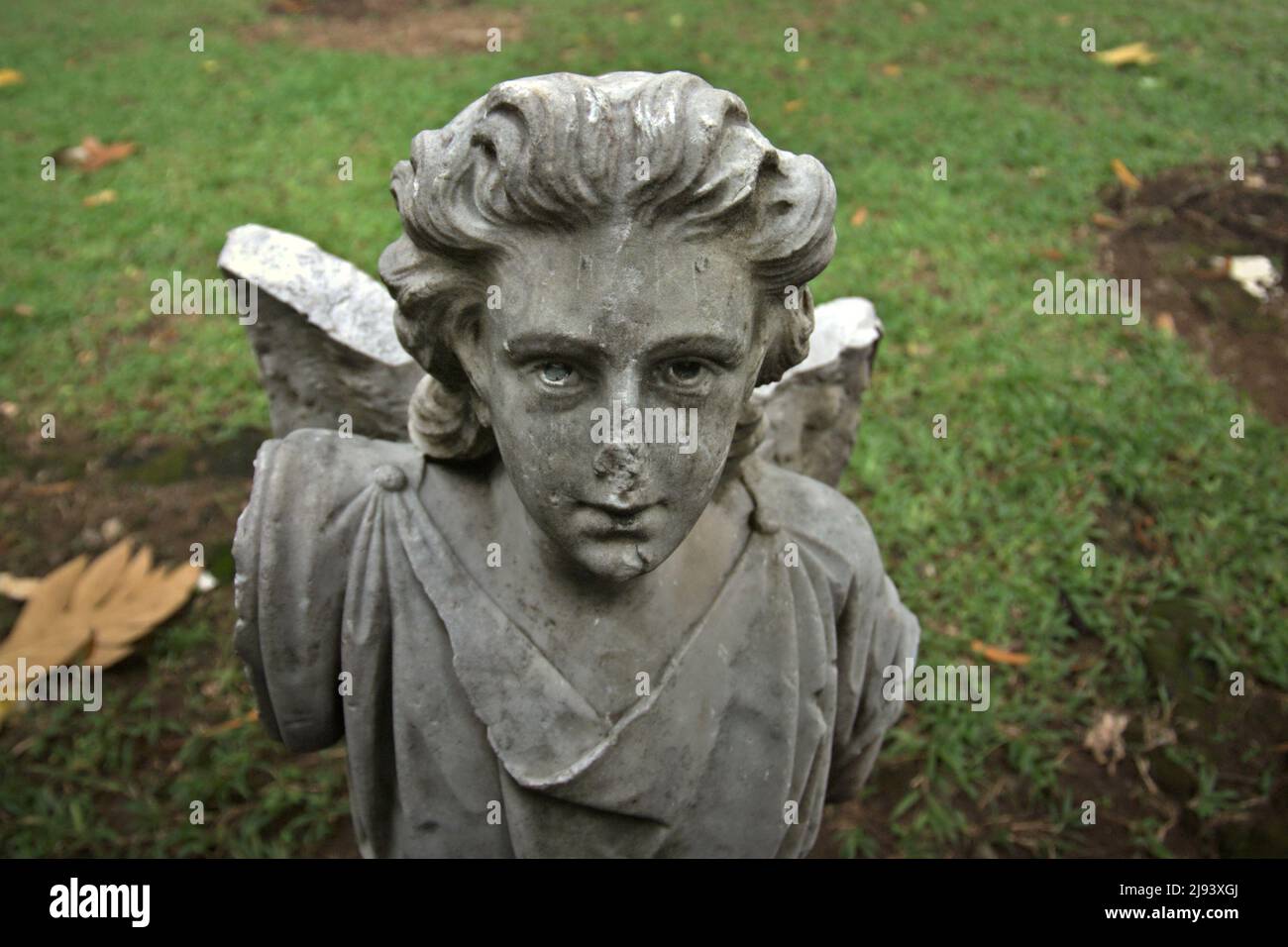 A broken statue of an angel figure at Taman Prasati museum (museum of memorial stone park) in