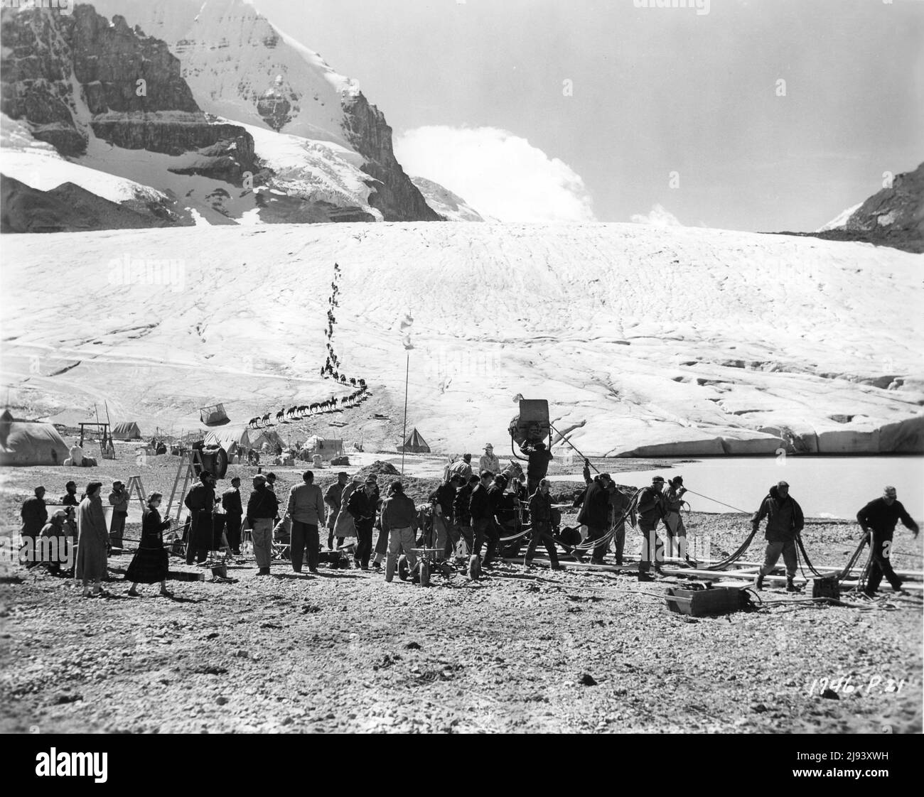 JAMES STEWART (on horse) and Movie Crew on set location candid filming on the Athabasca Glacier in Jasper National Park, Canada for THE FAR COUNTRY 1954 director ANTHONY MANN story / screenplay Borden Chase cinematography William H. Daniels Universal International Pictures Stock Photo
