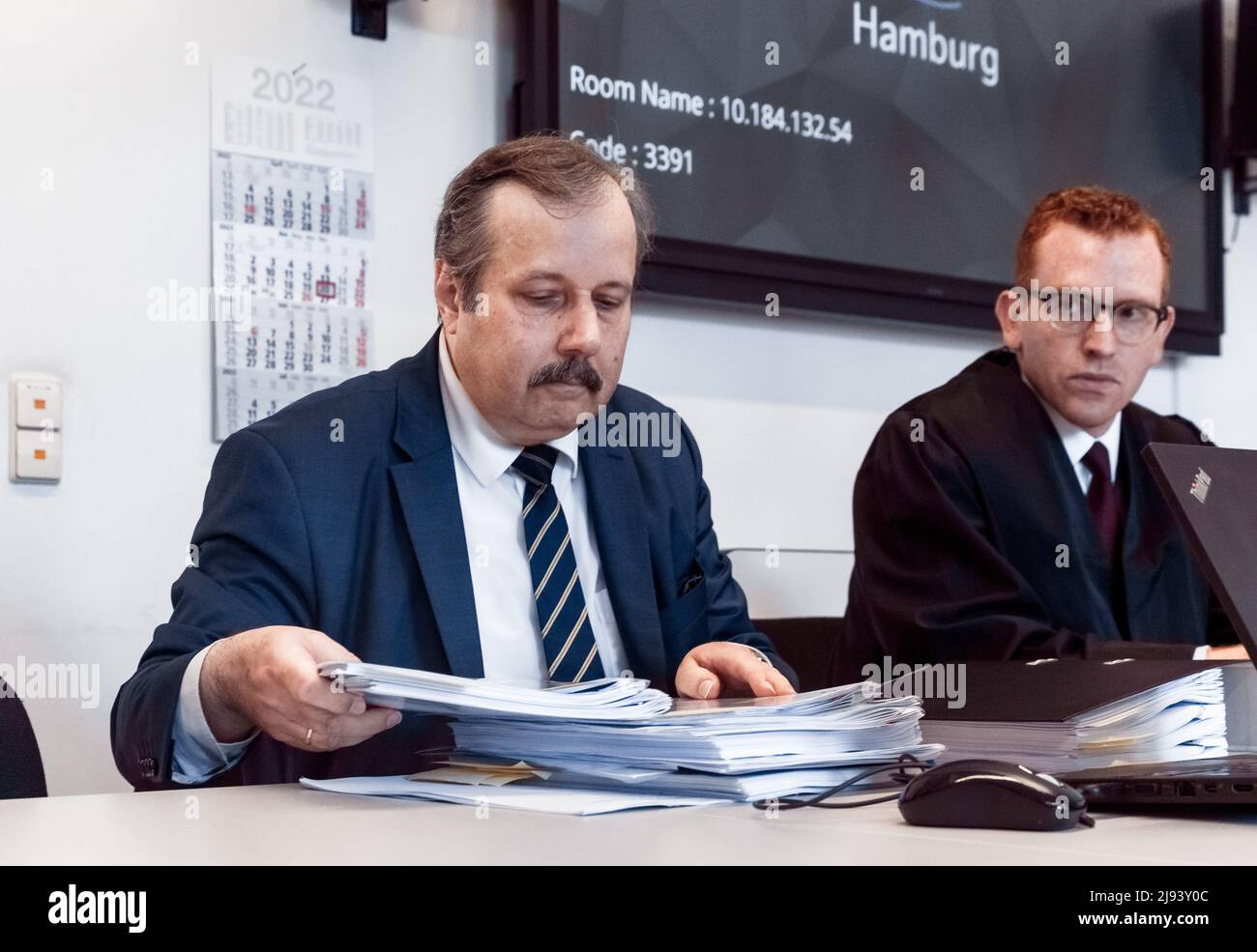 20 May 2022, Hamburg: Physicist Roland Wiesendanger (l) sits next to his lawyer Lucas Brost in a hall of the Hamburg Civil Justice Building before the oral hearing in the dispute over the origin of the corona virus between him and virologist Drosten. In an interview, the Hamburg nanoscientist accused Drosten, director of the Institute of Virology at Berlin's Charité hospital, of deliberately deceiving society about the origin of the corona pandemic. Drosten had obtained an injunction against the repetition of this claim, against which Wiesendanger filed an appeal. Photo: Markus Scholz/dpa Stock Photo