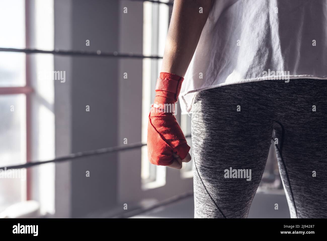 Midsection of caucasian young female boxer wearing red boxing wrap