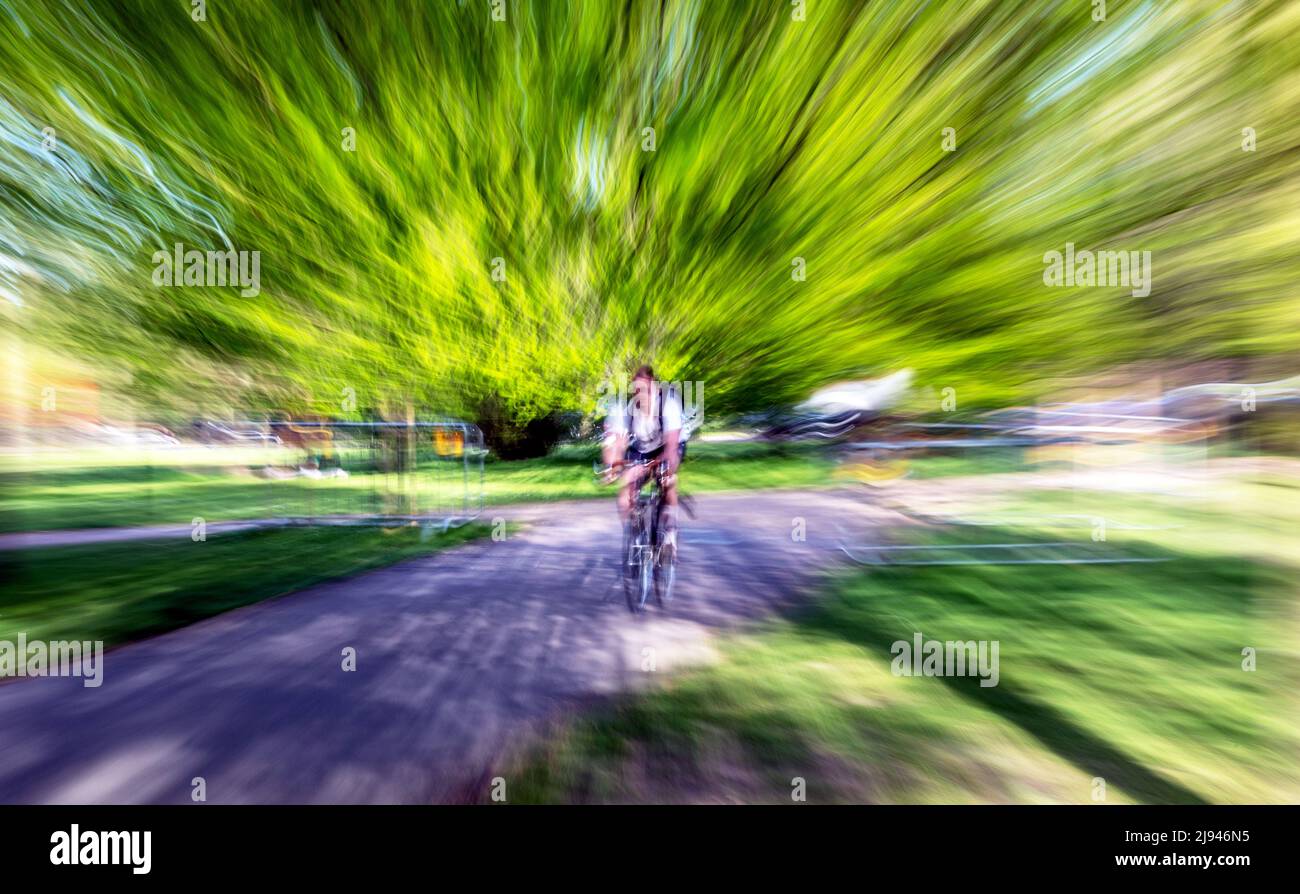 Zoom Blur Image of a Cyclist In Hyde Park London UK Stock Photo