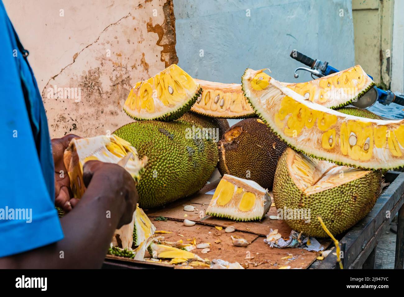Jackfruit beeing cut on the street of Stone Town, Zanzibar, Tanzania Stock Photo