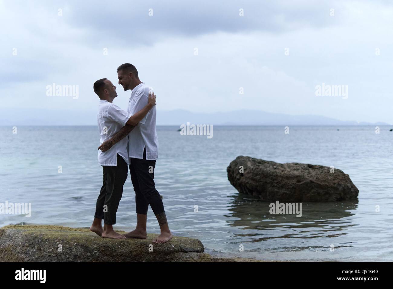 Gay couple about to kiss next to the ocean Stock Photo