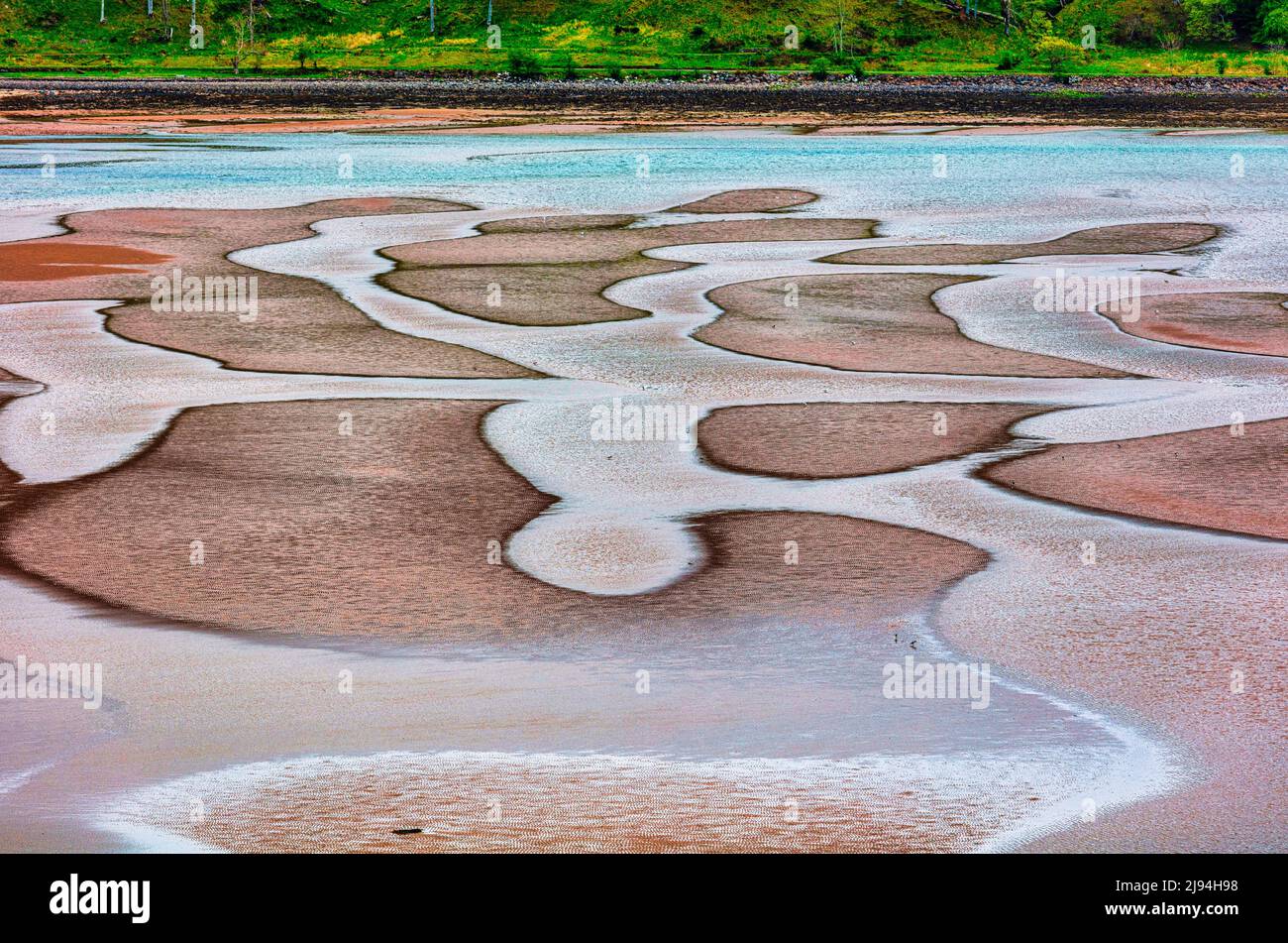 Wave scuptured ripples form colourful sand patterns on the beach  in Applecross Bay at low tide,  Applecross Peninsula,  Wester Ross, Scotland, Stock Photo
