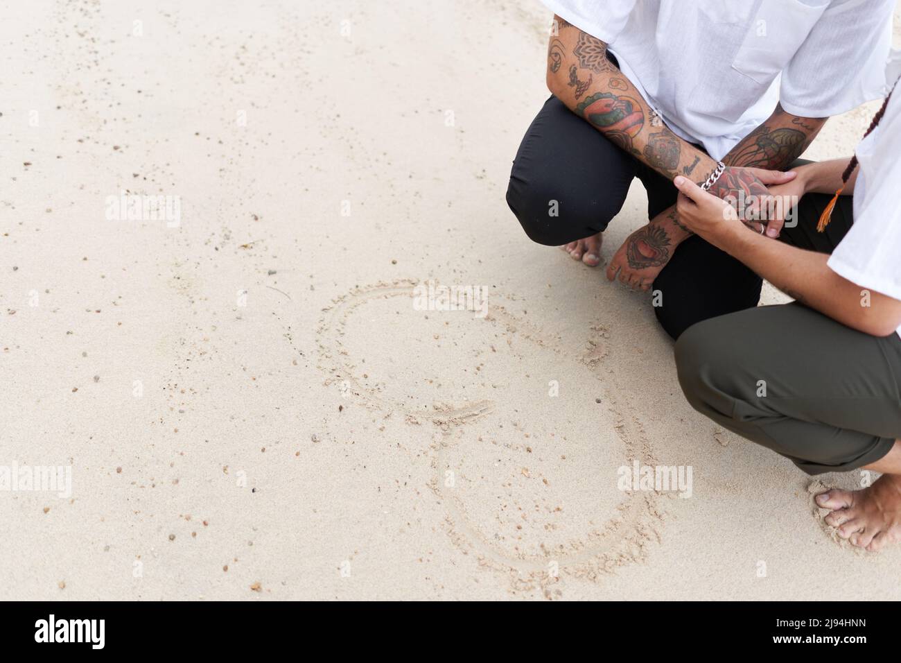 Engraved in the sand of a heart next to a gay couple Stock Photo