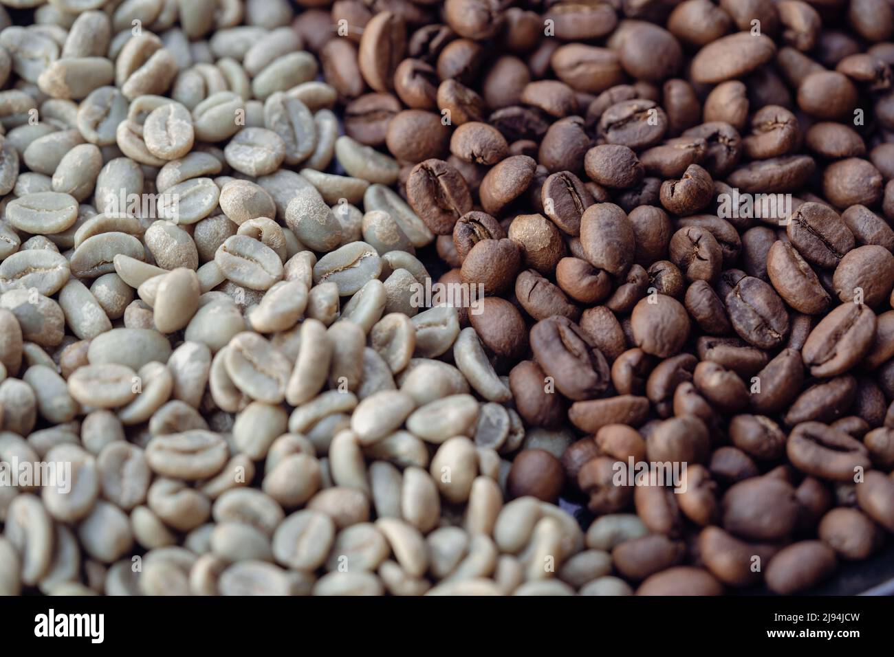 A pile of natural raw and brown roasted coffee beans Stock Photo - Alamy