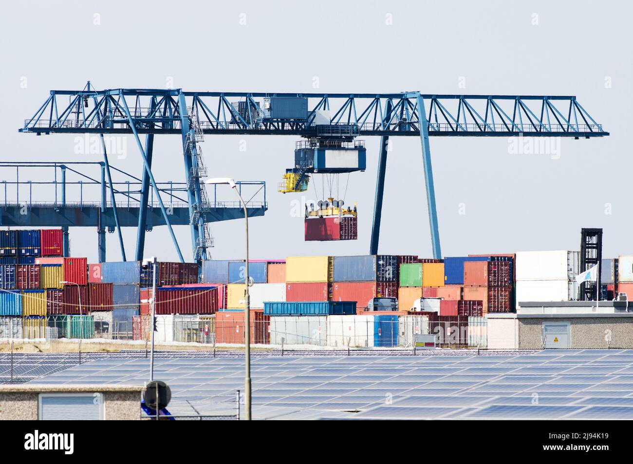 Container terminal with blue large industrial container crane in Nijmegen in the Netherlands Stock Photo