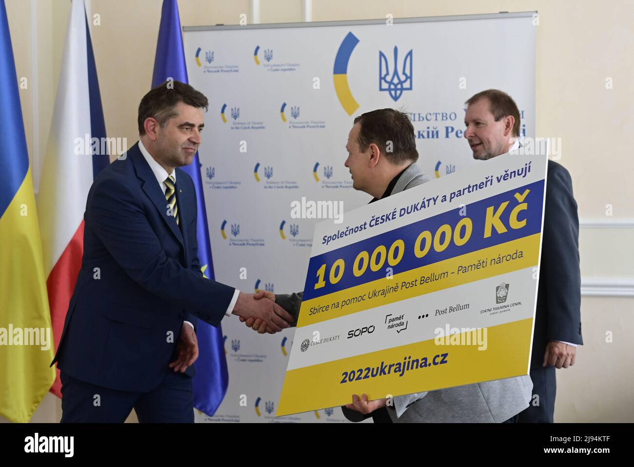 Prague, Czech Republic. 20th May, 2022. The Czech Ducats company handed over the first 10 million crowns to Ukraine through the Post Bellum organization at the Ukraine embassy in Prague, Czech Republic, May 20, 2022. It took place on the occasion of the printing of the charity banknote Glory to Ukraine. From left Ukrainian Ambassador in Czech Republic Yevhen Perebyjnis, Post Bellum director Mikulas Kroupa and the Czech Ducats company CEO Radek Sulta. Credit: Roman Vondrous/CTK Photo/Alamy Live News Stock Photo