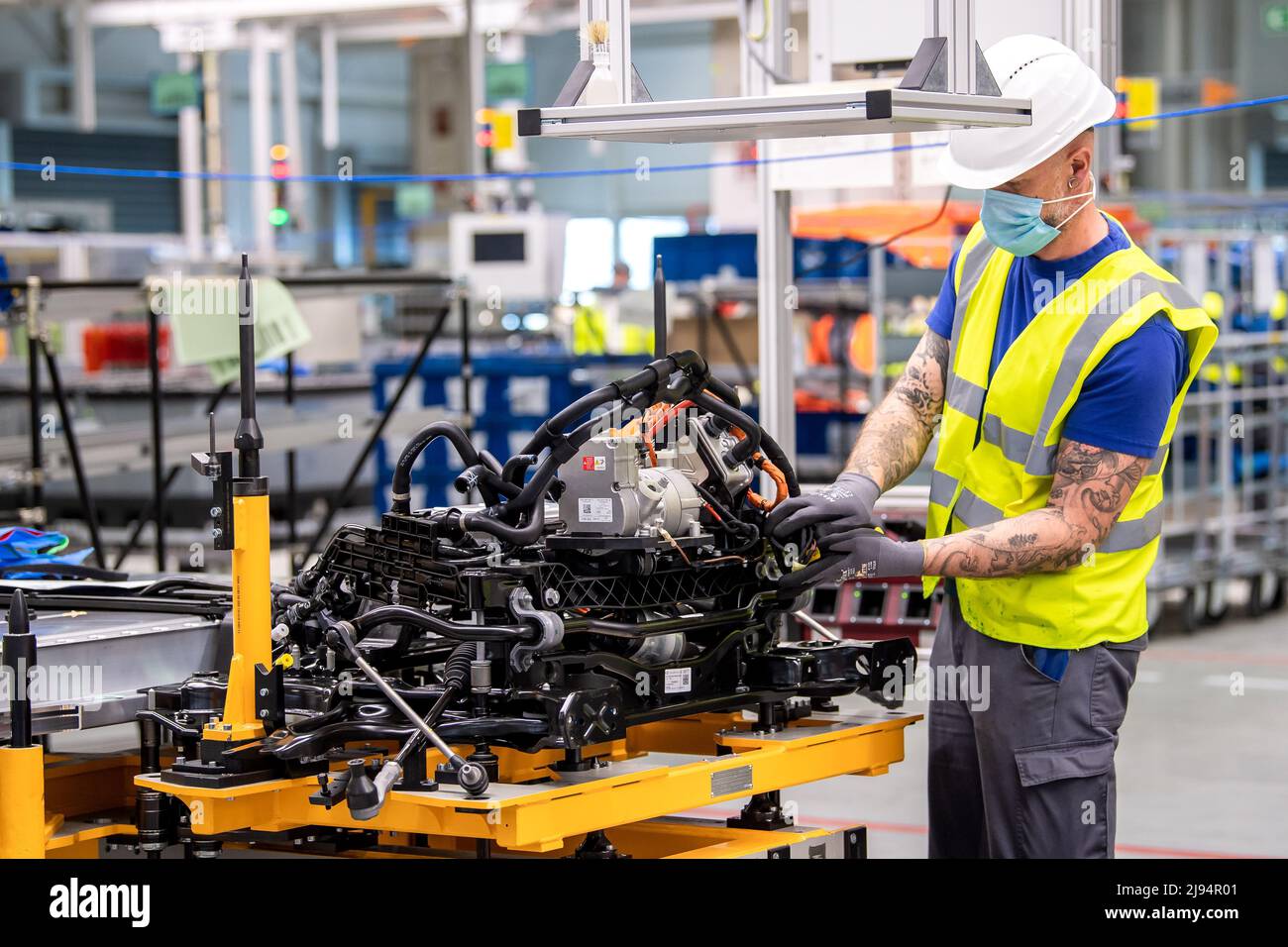Emden, Germany. 20th May, 2022. A VW employee works on the underbody with the battery for the ID.4. Volkswagen has started series production of the all-electric ID.4 compact SUV at its plant in Emden, East Frisia. After the start-up phase, 4000 e-vehicles per week are to be produced in Emden by the end of the year. Credit: Sina Schuldt/dpa/Alamy Live News Stock Photo