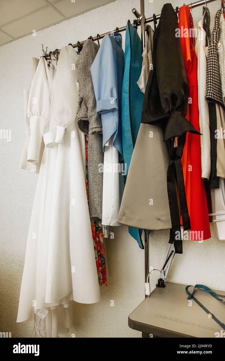 https://c8.alamy.com/comp/2J94RYD/different-dresses-hang-on-rail-in-the-atelier-hand-made-womans-clothes-slow-fashion-2J94RYD.jpg